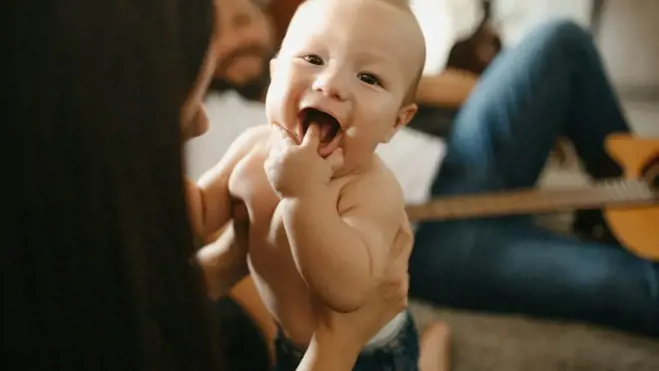 Eine Frau sitzt auf dem Boden und hält ein Baby – ein Symbol für Fürsorge und Familie im Zusammenhang mit Tipps zur Empfängnis.