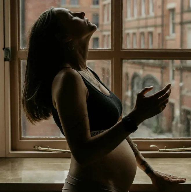 Pregnant woman by a window representing how sperm can survive up to five days inside the female reproductive system