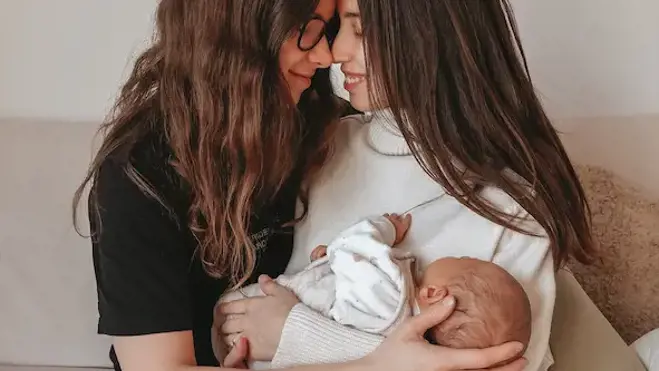 Jo and Viv holding their baby after their journey to parenthood