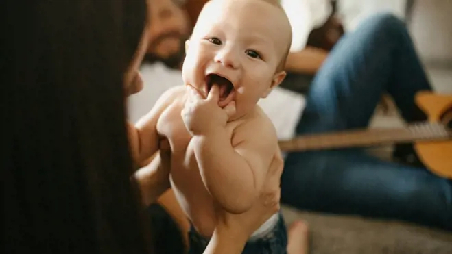 A woman sitting on the floor, holding a baby, symbolizing nurturing and family in the context of conception tips.